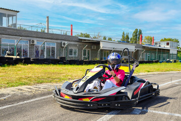 Teenage girl in a kart racing car at the start of a race