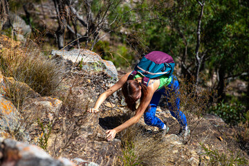 adventurous girl rock climbing to the top of mount may, dangerous climb in mount barney national...