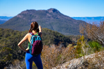 Naklejka na ściany i meble hiker girl looking at the peak of mount maroon from the top of mount may in mount barney national park, south east queensland, australia