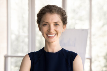 Head shot young ambitious woman employee, staff member posing at workplace. Portrait of successful,...