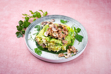 Traditional savoy cabbage lasagne with mashed potatoes and mushrooms served as a close-up on a design plate with text space