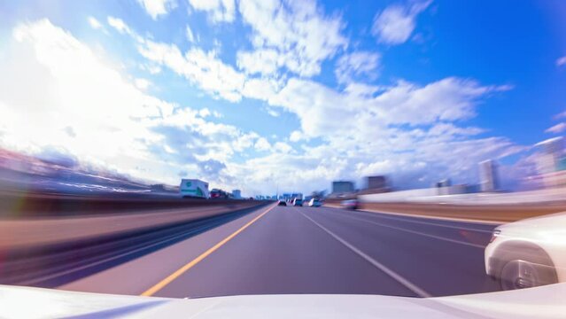 Open road highway 401 fast car hyper lapse in Toronto, Ontario, Canada. Road trip travel timelapse in America. Long exposure motion time lapse of a speedy Canadian vehicle drive during day.