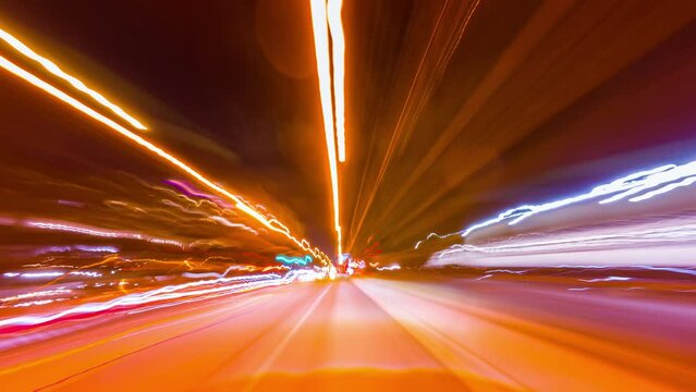 Bright long exposure motion hyperlapse of a speed driving in Toronto, Ontario, Canada. Speedy car front POV view at the highway with a lot of traffic lights stricks. Passing by city downtown buildings