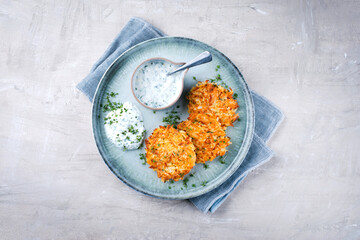 Traditional parsnip potato pancakes with chives and quark dip served as a top view on a Nordic...