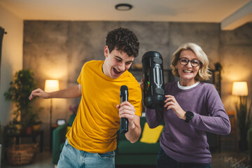 mother and son mature woman teenage man happy smile sing dance at home - obrazy, fototapety, plakaty