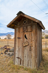 An old wooden outhouse with an out of order sign