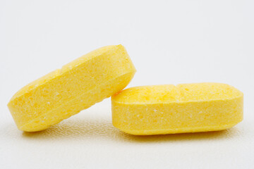 Single yellow tablet against blue background