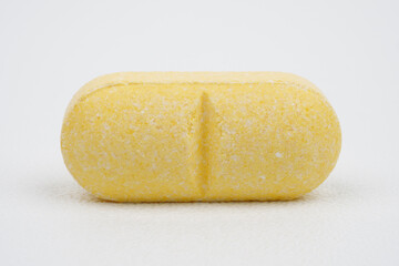 Single yellow tablet against blue background