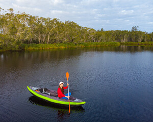 aerial view of adventurous girl paddling on an inflatable kayak through unique noosa everglades; idyllic scenery of noosa river in south east queensland, australia; kayaking in noosa
