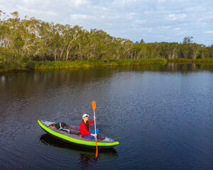 aerial view of adventurous girl paddling on an inflatable kayak through unique noosa everglades;...