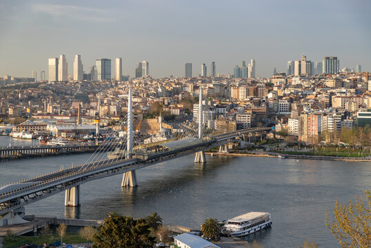 Istanbul, Turkey - April 14, 2023: A picture of the Golden Horn Bridge and the Beyoglu district, with high rises of the Sisli district in the distance.