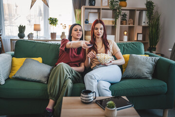 two women caucasian teenage friends or sisters watch movie tv at home
