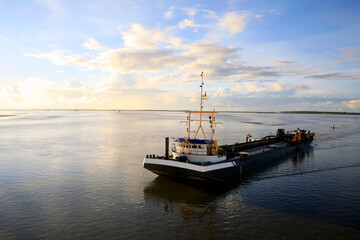 Dredger vessel in the Wadden Sea preventing the fairway from silting up - 749663789