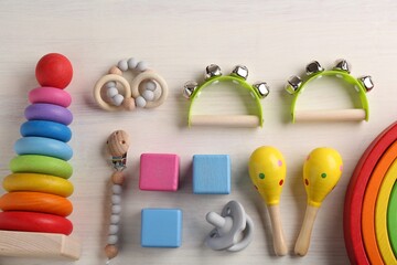 Baby song concept. Flat lay composition with toy musical instruments on white wooden background