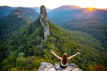 hiker girl enjoys the sunset over unique australian mountains in main range national park, queensland; famous steamers trailhead near mount superbus - obrazy, fototapety, plakaty
