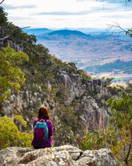 Naklejka na ściany i meble hiker girl admiring the panorama of mountains on the way to the top of mount maroon, mount barney national park, queensland, australia