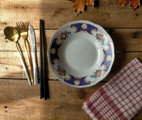 plate with spoon and fork on wooden table