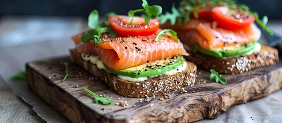 Foto auf Acrylglas Two freshly made salmon and avocado club sandwiches are neatly arranged on a rustic wooden cutting board, with toppings like lettuce, tomato, and mayonnaise adding color and texture to the dish. © TheWaterMeloonProjec