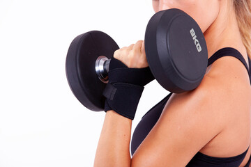 Sports girl with dumbbells in her hands on a light background - 749681147