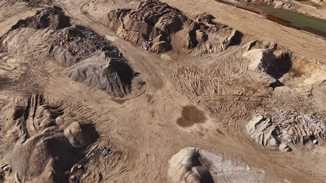 Aerial drone footage (top view) of a construction site. Construction equipment works on the construction site bulldozer prepare the sand top view drone overhead shot.
