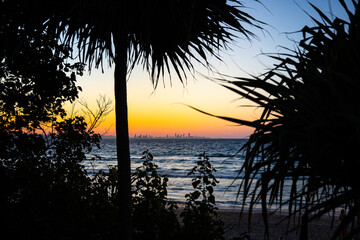 colorful sunset over the beach in coolangatta near point danger, gold coast, queensland, australia; gold coast skyscrapers in the background
