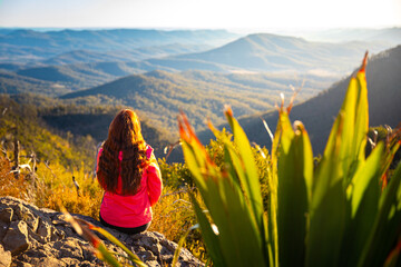 beautiful hiker girl enjoying sunset over unique, folded mountains in south east queensland,...