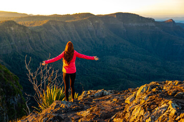 beautiful hiker girl enjoying sunset over unique, folded mountains in south east queensland,...