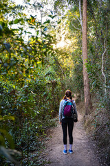 pretty girl with a backpack enjoys afternoon walk at enoggera reservoir in brisbane, queensland,...