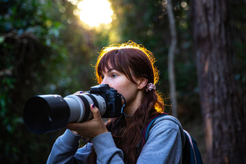 wildlid photographer looking for wild native animals and birds during afternoon walk at enoggera reservoir in brisbane, queensland, australia; warm sunset in a park	