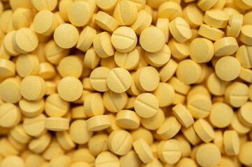 Full frame shot of yellow pills. Medicines are chemicals or compounds used to cure, halt, or prevent disease.