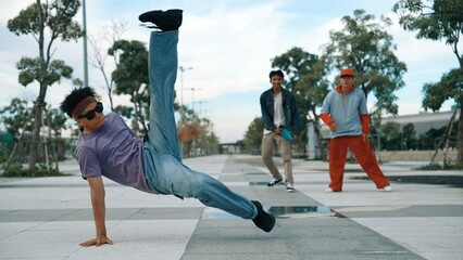 Attractive dancer perform break dance or freestyle dance in front of friend cheering at him....