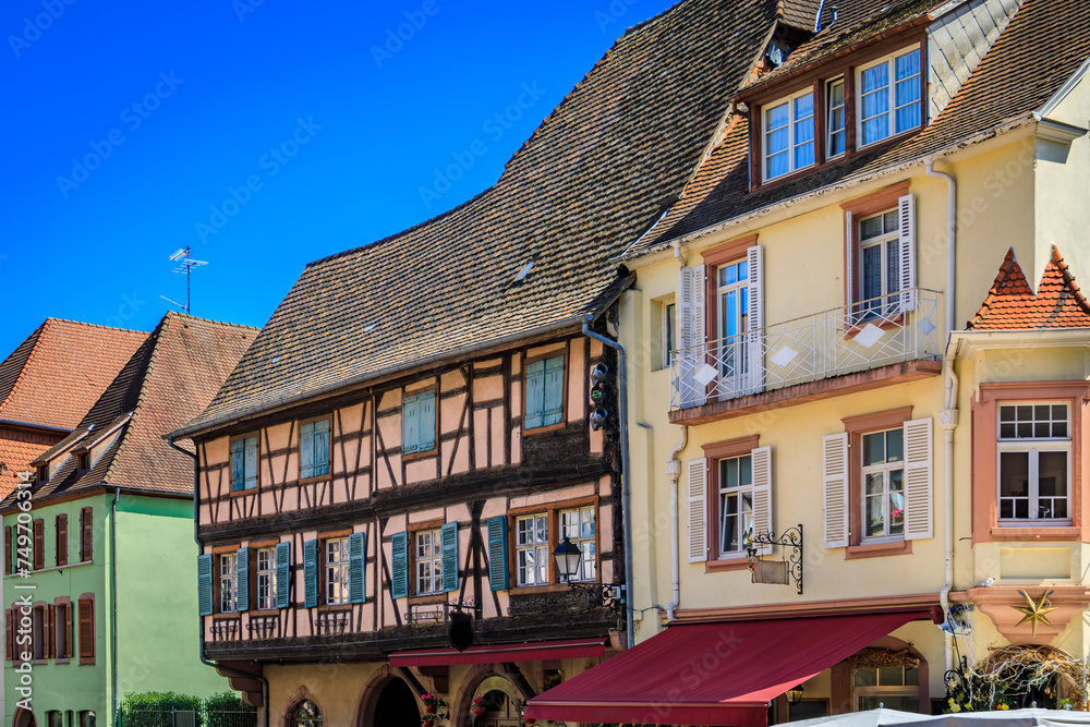 Wall mural Ornate traditional half timbered houses with blooming flowers in a popular village on the Alsatian Wine Route in Kaysersberg, France