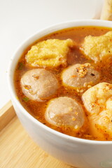 Close-up of beef meatball, crafted from minced beef and tapioca flour, a key element in Cuangkie meatball dish, immersed in spicy red broth.