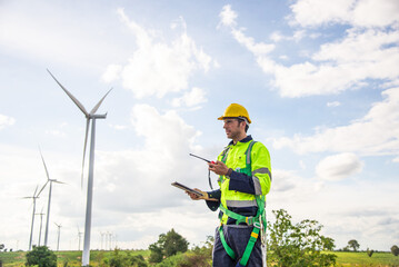 Wind turbine engineer liaising in wind farm, sustainable energy industry concept.