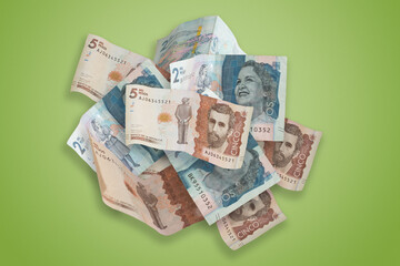 Stacks of 2000 and 5000 colombian pesos COP,  isolated on green background.