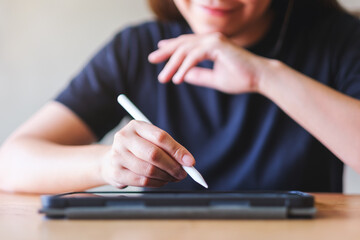 Closeup of a woman using stylus pen technology for working and writing on digital tablet screen