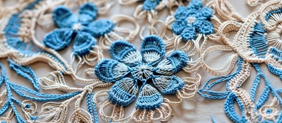 A detailed close-up of a handcrafted blue and white lace napkin, showcasing intricate crochet patterns and delicate stitching. The contrasting colors of blue and white create a visually striking