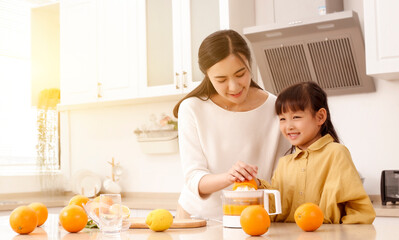 Making in the kitchen Asian mother making juice for daughter to drink