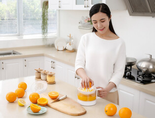 Asian girl making juice in kitchen