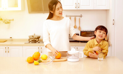 Making juice in the kitchen. Asia. Mother and daughter making juice together.