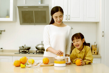 Asian mother making fresh juice with her daughter