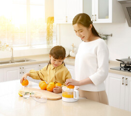 Asian mother making fresh juice with her daughter