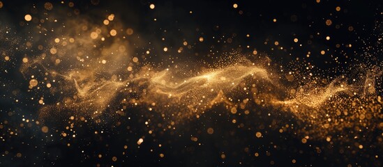 Numerous particles of gold dust are scattered across a dark black background, creating a captivating and mesmerizing effect. The dust appears blurred, adding to the dynamic and intriguing visual