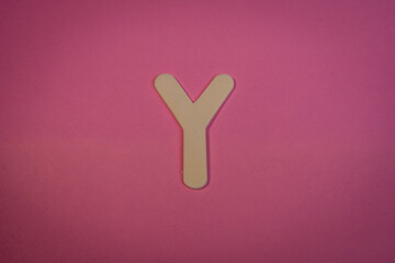 Letter Y in wood on a pink background