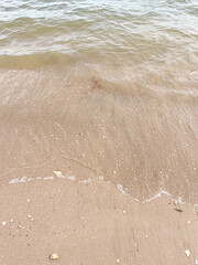Soft wave of blue ocean on sandy beach. Background.