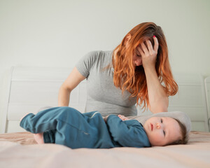 A woman sits on her child's bed and cries. Postpartum depression. 