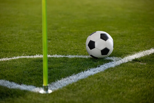 Close up photo of a soccer ball resting on the corner circle ready for a corner kick during a soccer game. Selective focus on the ball. Good generic soccer image.