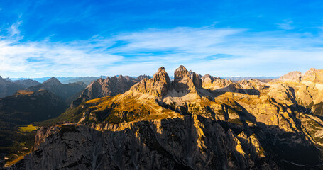 Rocky tops of Three peaks of Lavaredo above canyon at sunset