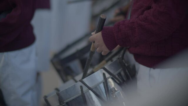 manos de ni&ntilde;os tocando el tambor escolar