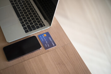 Credit card, laptop and smartphone on table, online shopping